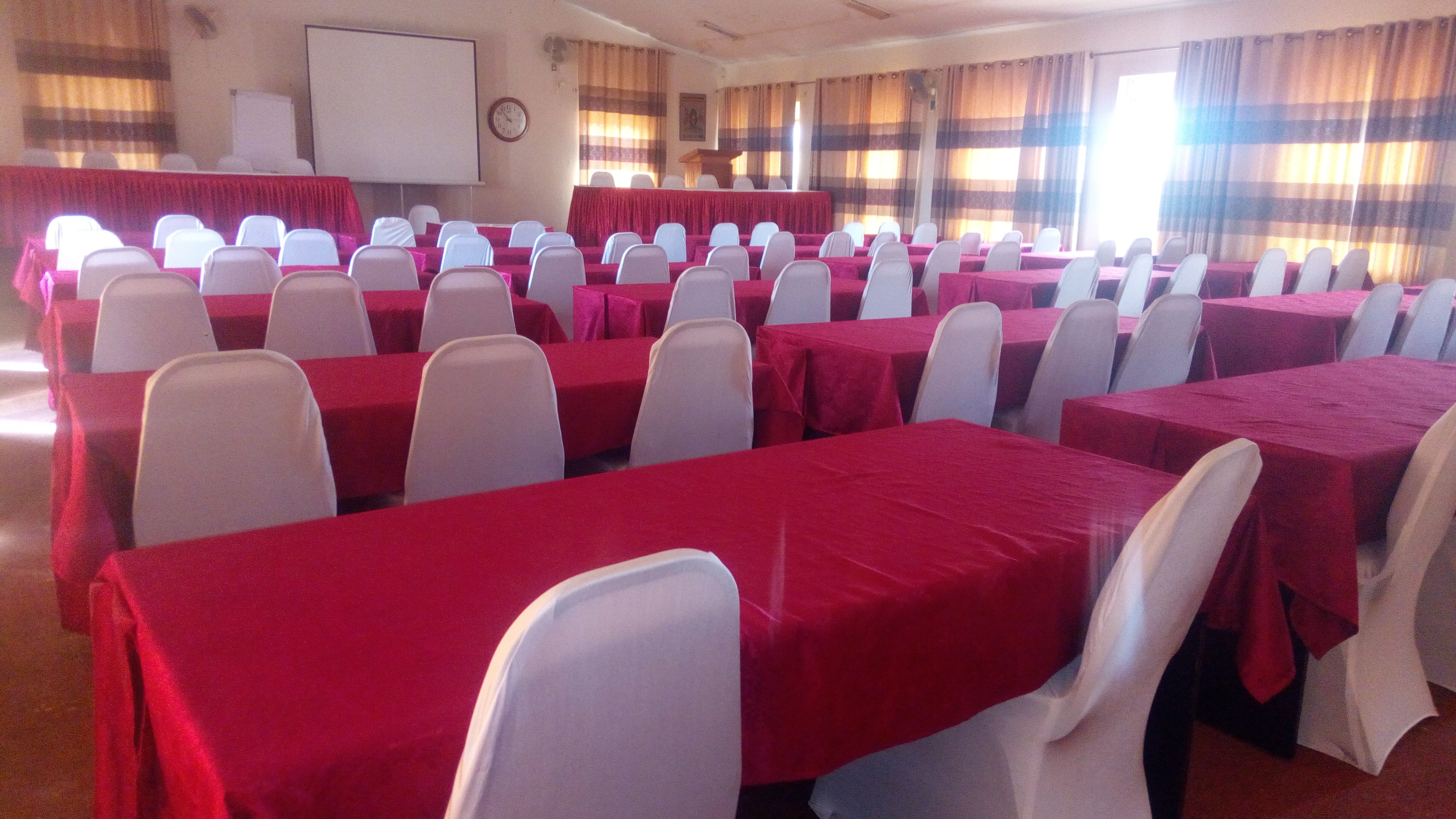 Conference hall with rows of red-covered tables